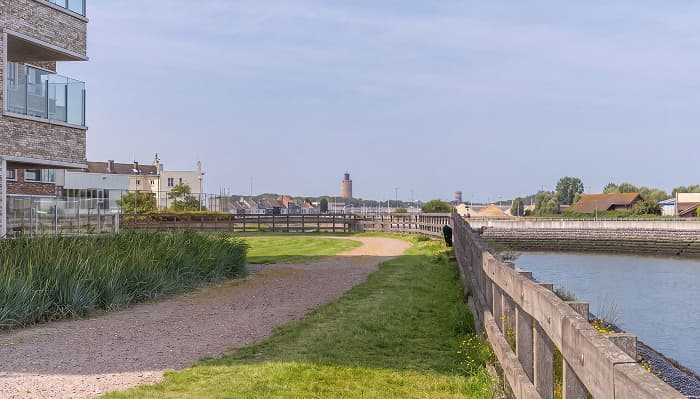 Pad langs het water bij De Parels, met de vuurtoren van Oostende