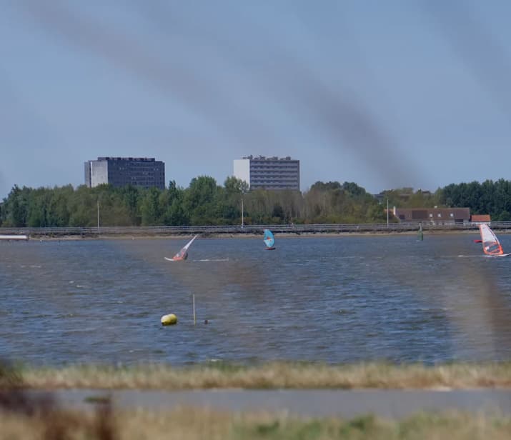 Windsurfers op de Spuikom met de skyline van Oostende